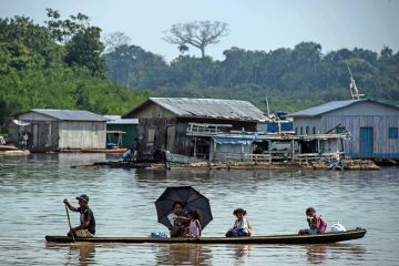 A fisherman takes his family on a canoe along the Jurua river