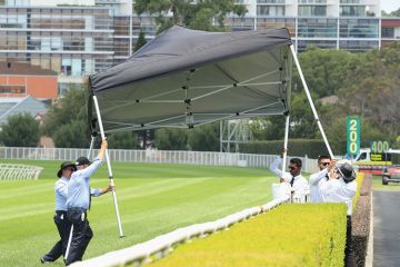 People stop a gazebo from blowing away