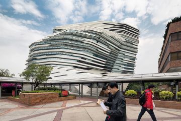 People walking past Jockey Club Innovation Tower, Hong Kong, China. Part of Hong Kong Polytechnic University