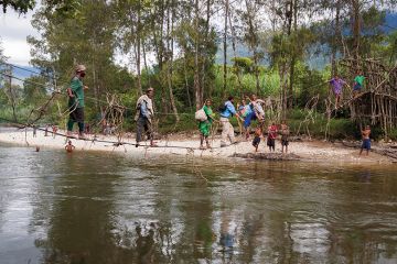 People cross a river in Papua New Guinea