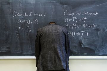 A teacher turned to face the blackboard