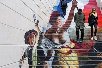 A couple walking down steps with graffiti in the background A couple walking down steps with graffiti in the background