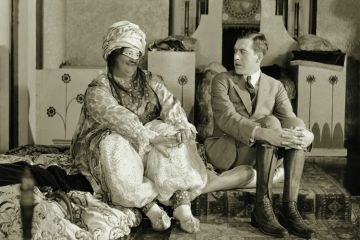 Man looking uncomfortable as woman looks at him Man looking uncomfortable as woman looks at him