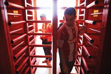 Supporters enter the ground through the turnstiles prior to the Barclays Premier League match between Stoke City and Norwich City at the Britannia Stadium in Stoke on Trent, England Supporters enter the ground through the turnstiles prior to the Barclays Premier League match between Stoke City and Norwich City at the Britannia Stadium in Stoke on Trent, England