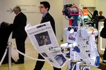A robot holds a newspaper during a demonstration at the World Economic Forum (WEF) annual meeting in Davos A robot holds a newspaper during a demonstration at the World Economic Forum (WEF) annual meeting in Davos