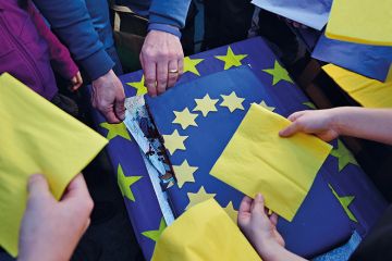 A man cuts a piece of an EU cake