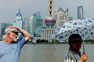 People walk along the Bund in front of the skyline of the city's financial district of Pudong, in Shanghai People walk along the Bund in front of the skyline of the city's financial district of Pudong, in Shanghai