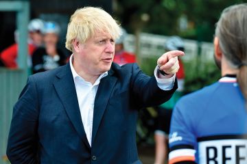 Britain's Prime Minister Boris Johnson (L) gestures as he talks to members of a local cycling club at the Canal Side Heritage Centre in Beeston, central England, on July 28, 2020 Britain's Prime Minister Boris Johnson (L) gestures as he talks to members of a local cycling club at the Canal Side Heritage Centre in Beeston, central England, on July 28, 2020