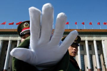 A Chinese paramilitary policeman gestures towards a photographer to stop taking pictures while standing guard at the Great Hall of the People, Beijing A Chinese paramilitary policeman gestures towards a photographer to stop taking pictures while standing guard at the Great Hall of the People, Beijing