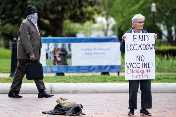 A lone protester holds a sign calling for an end to the lockdown and claiming chloroquine works as she stands in front of the White House in Washington on Saturday, April 25, 2020. A lone protester holds a sign calling for an end to the lockdown and claiming chloroquine works as she stands in front of the White House in Washington on Saturday, April 25, 2020.