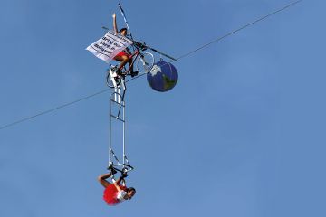 Tightrope artists balance a globe