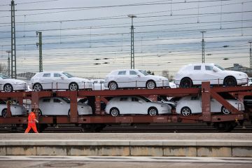 New Audi AG automobiles, manufactured by Volkswagen AG, sit under protective covers on a railway transporter beside a platform at Ingolstadt central train station in Ingolstadt, Germany New Audi AG automobiles, manufactured by Volkswagen AG, sit under protective covers on a railway transporter beside a platform at Ingolstadt central train station in Ingolstadt, Germany
