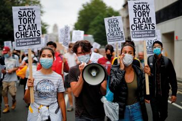 Students hold a placards as they march in central London on August 14, 2020 to protest against the downgrading of A-level results Students hold a placards as they march in central London on August 14, 2020 to protest against the downgrading of A-level results