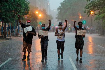 People holds signs as they walk in the rain after attending a Black Lives Matter protest in front of Lafayette Park next to the White House, Washington, DC on June 5, 2020 People holds signs as they walk in the rain after attending a Black Lives Matter protest in front of Lafayette Park next to the White House, Washington, DC on June 5, 2020