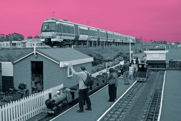 Miniature railway next to real train Miniature railway next to real train