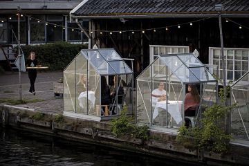 People have dinner in a so-called quarantine greenhouses in Amsterdam, on May 5, 2020 as the country fights against the spread of the COVID-19, the novel coronavirus.
