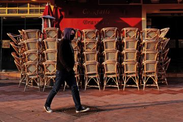 Man with facemask walking past closed cafe during coronavirus pandemic. France. Man with facemask walking past closed cafe during coronavirus pandemic. France.