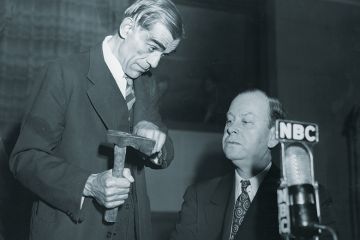 Man showing axe to another Man showing axe to another