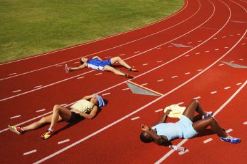 Tired runner lie on the track, illustrating a lack of resilience Tired runner lie on the track, illustrating a lack of resilience