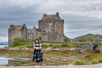 Tourist taking selfie at Eilean Donan Castle