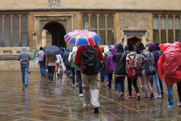 Tourists in rain outside Bodleian Library, University of Oxford