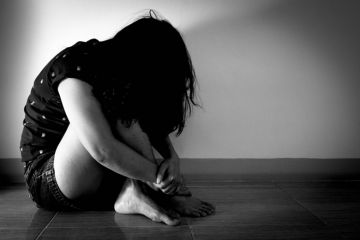 Trafficked woman sitting in the dark Trafficked woman sitting in the dark