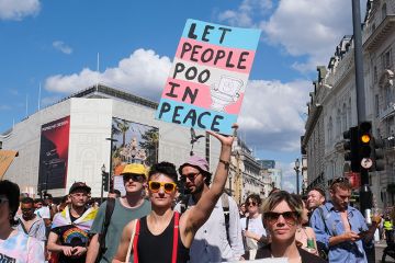 Person holding a sign stating “let us poo in peace” during the Trans Pride march in London, 2024. To illustrate that more UK universities will have to implement policies that restrict the facilities trans people can use after a Supreme Court ruling.