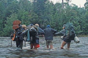 Trekkers crossing river, Tarkine rainforest Trekkers crossing river, Tarkine rainforest