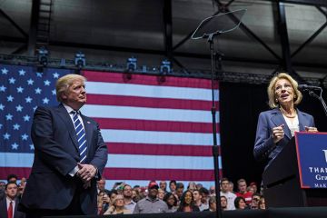 President-elect Donald Trump looks on as Betsy DeVos, his nominee for Secretary of Education, speaks at the DeltaPlex Arena, December 9, 2016 in Grand Rapids, Michigan. President-elect Donald Trump looks on as Betsy DeVos, his nominee for Secretary of Education, speaks at the DeltaPlex Arena, December 9, 2016 in Grand Rapids, Michigan.