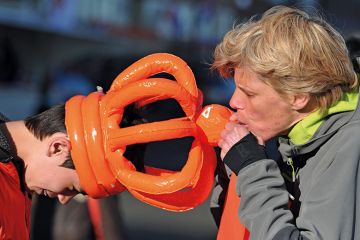 Person blows an inflatable orange crown Person blows an inflatable orange crown to illustrate Universal exams can fix the grade inflation crisis