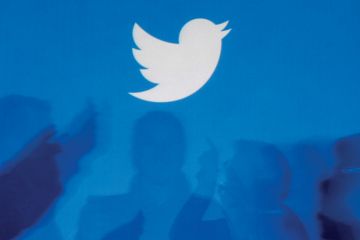 Twitter logo above silhouettes of people in discussion