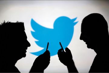 Men using smartphones against Twitter backdrop