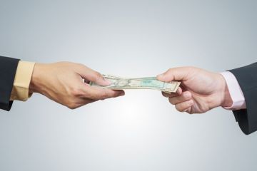 Two hands exchanging money