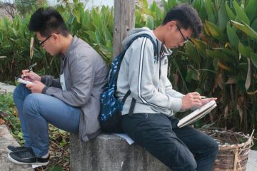 Two male art students sketching back-to-back, Hongcun village, Anhui, China