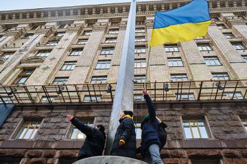 Activists hold Ukrainian flag during an action near the Kyiv City Council, demanding more money from the city budget for the Ukrainian armed forces