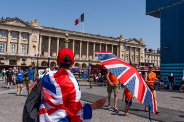 A spectator wrapped in a British Union flag shelters from the sun with an umbrella near the Paris 2024 Olympic Games Concorde stadium venue in Paris, France, 2024. To illustrate the return of the Erasmus+ programme. A spectator wrapped in a British Union flag shelters from the sun with an umbrella near the Paris 2024 Olympic Games Concorde stadium venue in Paris, France, 2024. To illustrate the return of the Erasmus+ programme.