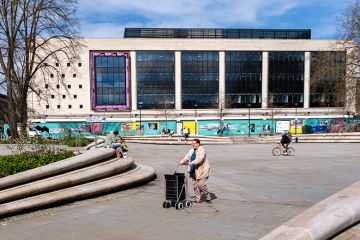 People on Kings Square, part of a regeneration project with the old Debenhams building becoming the University of Gloucestershire's City Campus, Gloucester, United Kingdom
