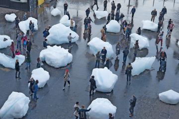 Visitors interact with blocks of melting ice from an exhibit outside Tate Modern in central London Visitors interact with blocks of melting ice from an exhibit outside Tate Modern in central London to illustrate A measure of reality