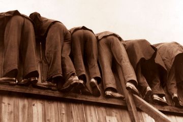 row of men bent over fence