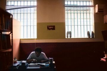 prisoner at desk with book