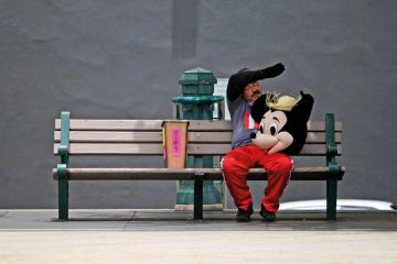 A street performer in a Mickey Mouse costume rests on a bench A street performer in a Mickey Mouse costume rests on a bench to illustrate We can’t stop the ‘rip-off degrees’ debate – but we can change its terms