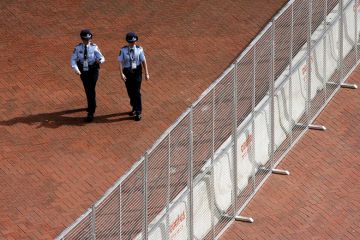 Two police officers walk alongside a steel and concrete fence erected around the Sydney Convention and Exhibition centre at Darling Harbour in Sydney Two police officers walk alongside a steel and concrete fence erected around the Sydney Convention and Exhibition centre at Darling Harbour in Sydney to illustrate Sharing ban bill could mean jail for researchers