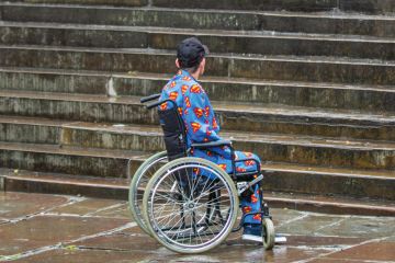 Man in wheelchair looking at steps Man in wheelchair looking at steps to illustrate Two-thirds of disabled PhD students poorly supported, says study