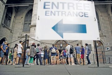 Tourists wait in line outside the Notre-Dame Basilica in Montreal, Quebec, Canada Tourists wait in line outside the Notre-Dame Basilica in Montreal, Quebec, Canada to illustrate Universities blindsided as Quebec set to double non-
