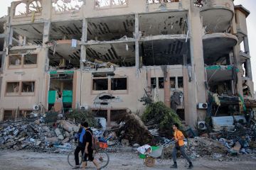Palestinians walks past the destroyed building of the Islamic University in Gaza City Palestinians walks past the destroyed building of the Islamic University in Gaza City to illustrate Academia in Gaza ‘has been destroyed’ by Israeli ‘educide’