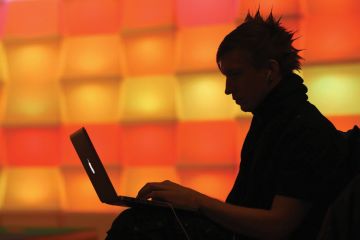 Man with laptop with bright orange background Man with laptop with bright orange background