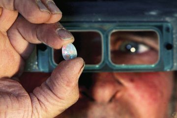  Opal miner holds a finished opal to illustrate Acclaim and anxiety as Australia streamlines funding bids