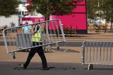 Workmen move barriers from outside the Olympic Stadium in Stratford Workmen move barriers from outside the Olympic Stadium in Stratford