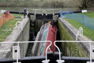 People look at a narrowboat that has capsized in a lock on the Kennet and Avon Canal People look at a narrowboat that has capsized in a lock on the Kennet and Avon Canal