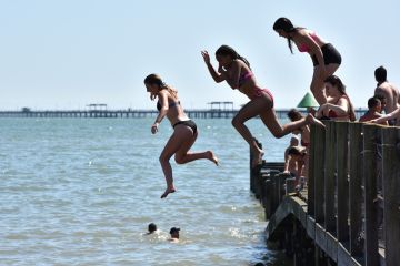 People jumping from a jetty into the sea in Southend-on-Sea, England People jumping from a jetty into the sea in Southend-on-Sea, England illustrate Value of domestic students almost halves at some UK universities
